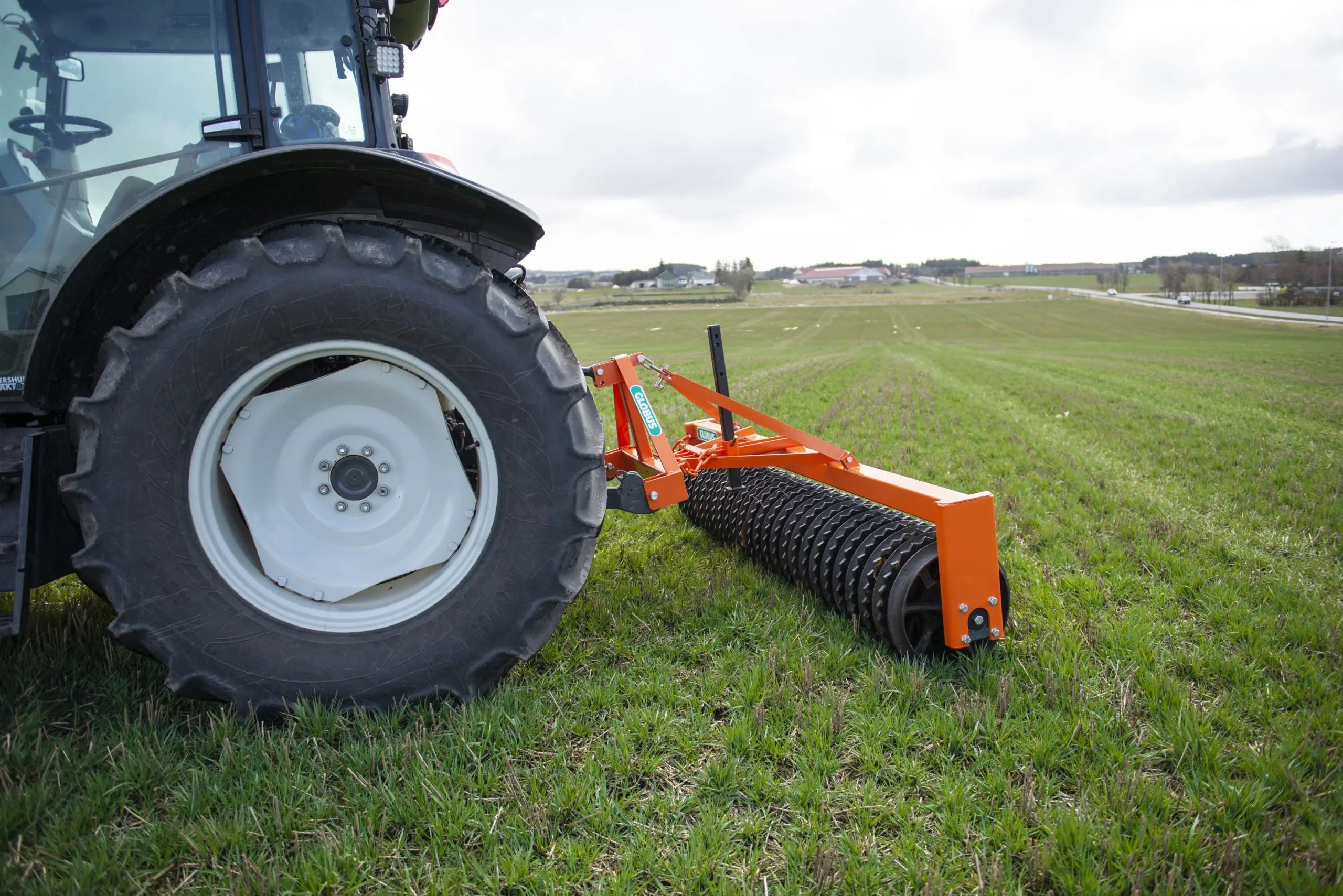 Et bilde av en Globus Cambridge Trommel i slep bak en traktor på et jorde